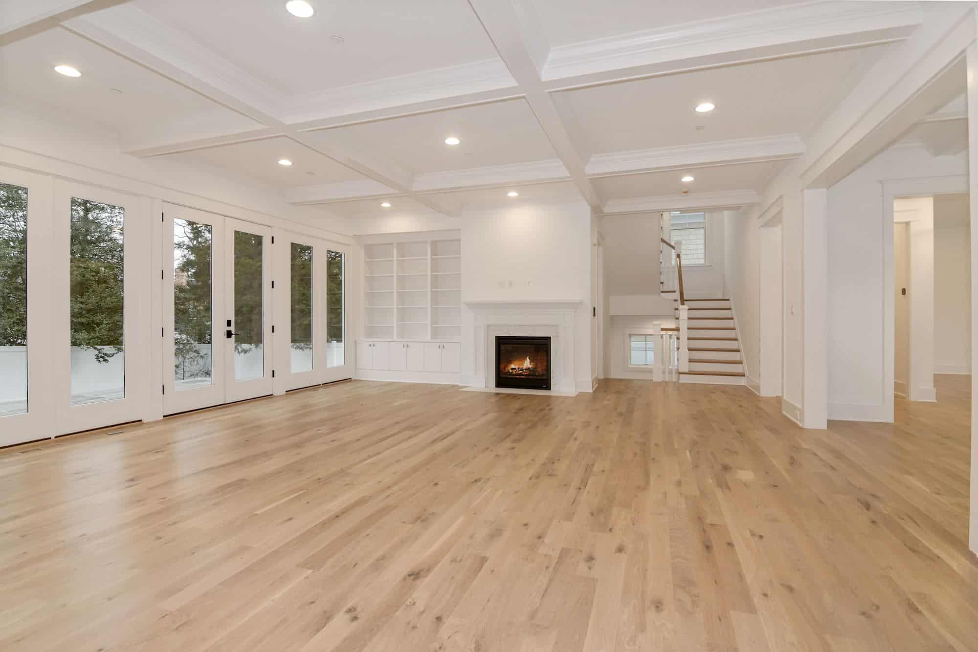 Fire lit, ceiling coffered, the room earns its square footage.