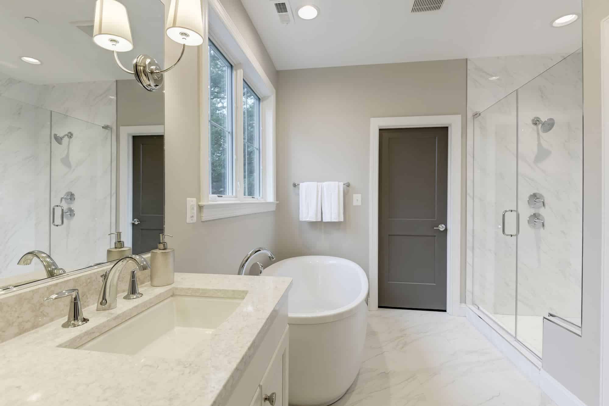 Freestanding tub, glass enclosure, every surface earns its place.