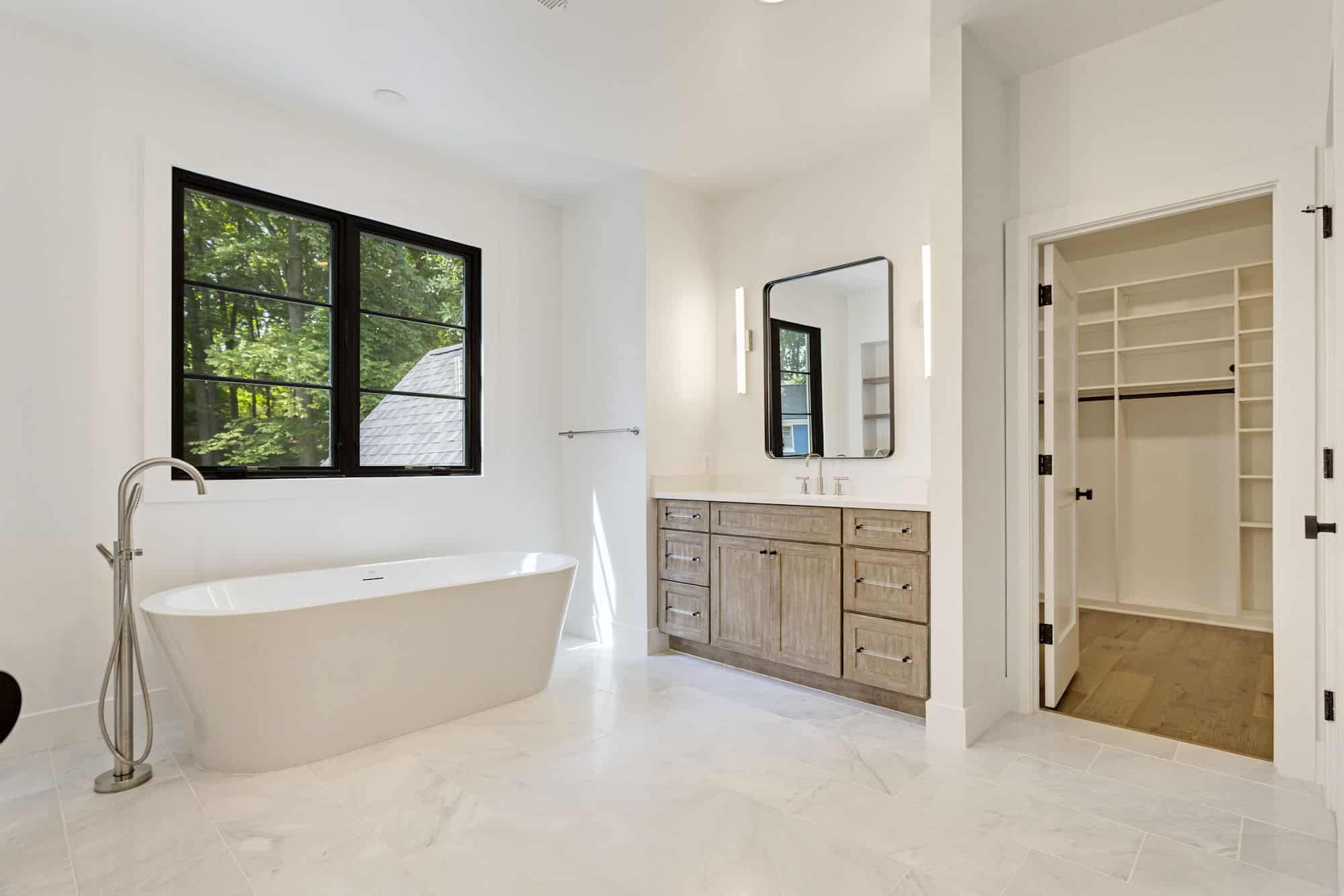 Freestanding tub centered under the canopy of trees.