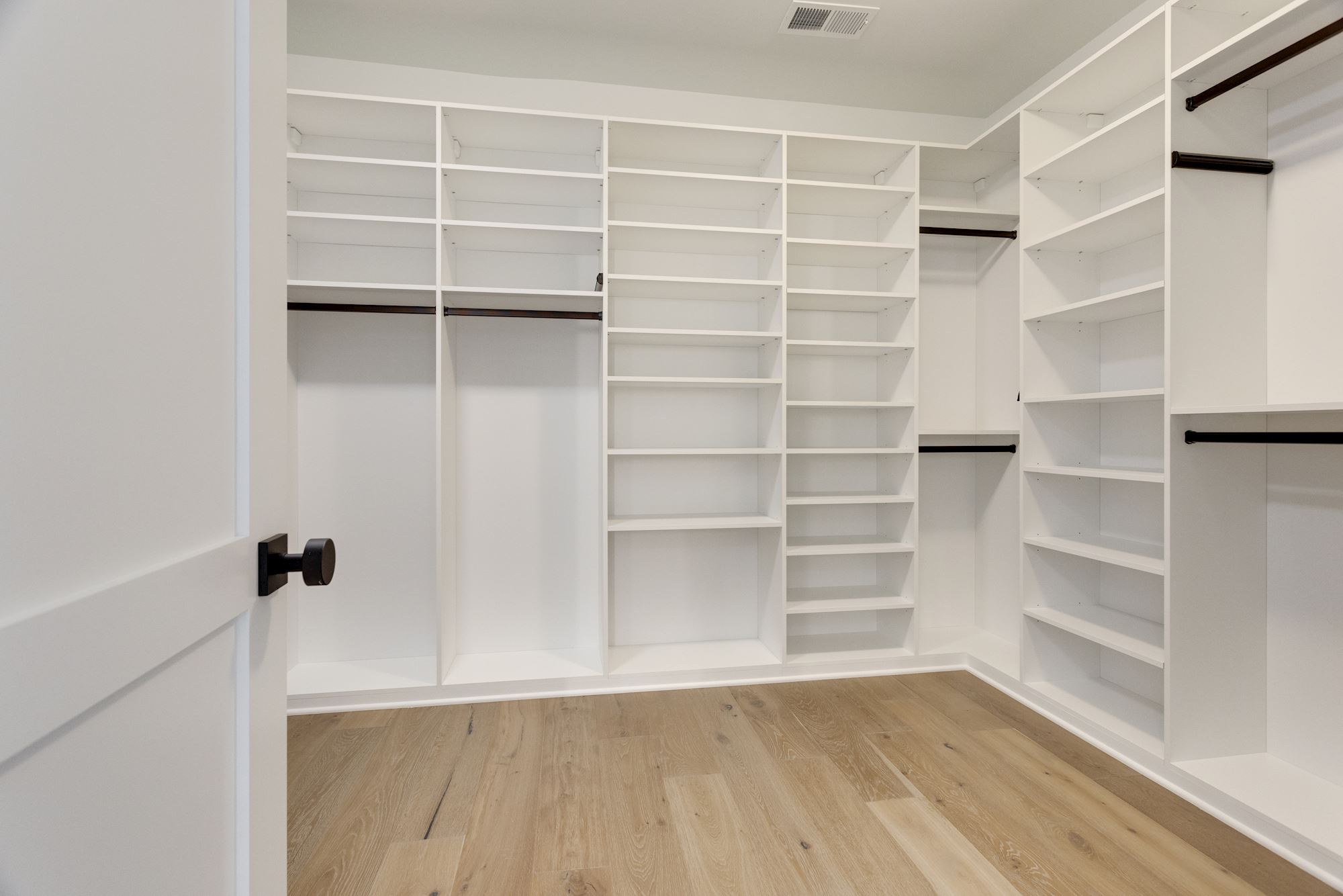 Custom walk-in closet with floor-to-ceiling built-ins.