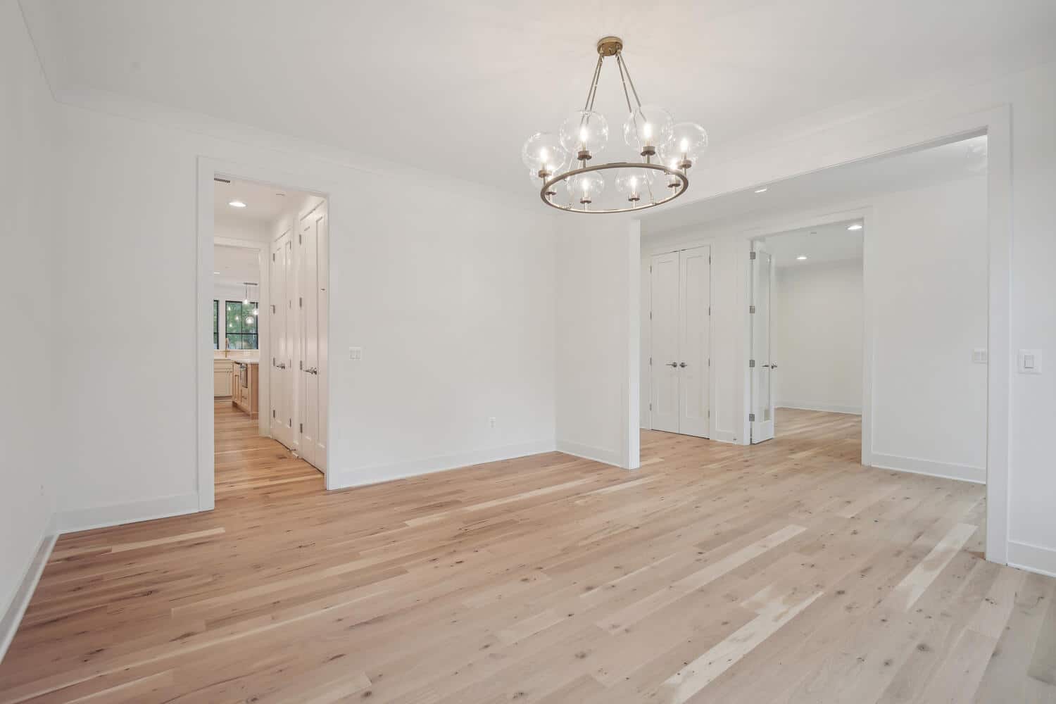 Chandelier centered, walls clear - the room defines itself.