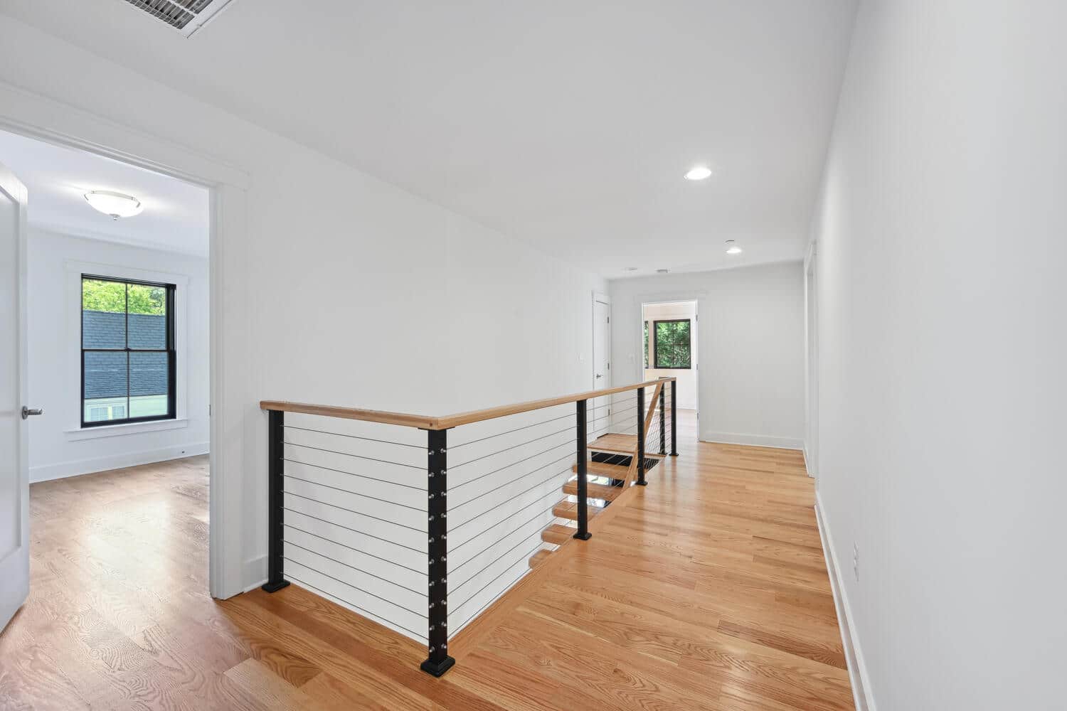 Open hall, cable rail, nowhere to hide the good bones.