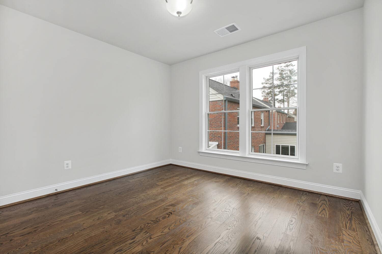 Wide window, clean walls, hardwood underfoot
