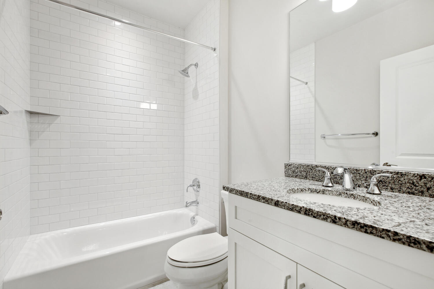 Subway tile surround, granite counter, clean lines