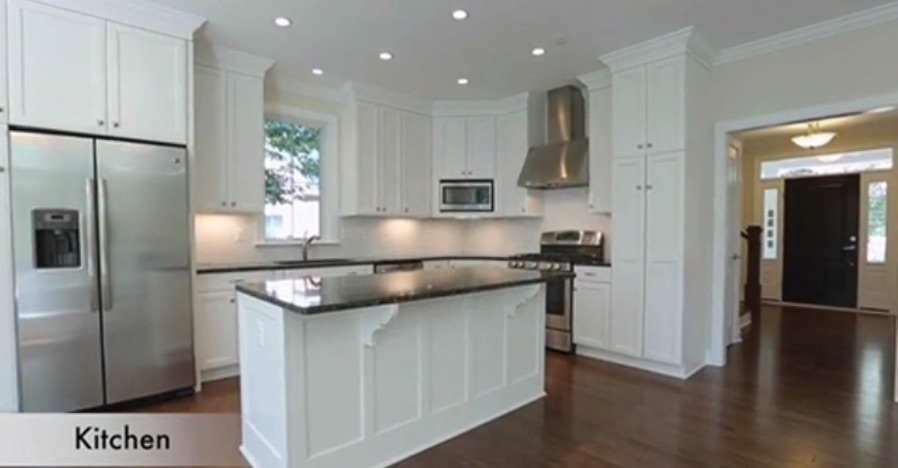 Spacious gourmet kitchen in the Greentree Model custom home by Paramount Construction featuring white shaker cabinets, granite countertops, stainless steel appliances, and a large center island in McLean, Virginia