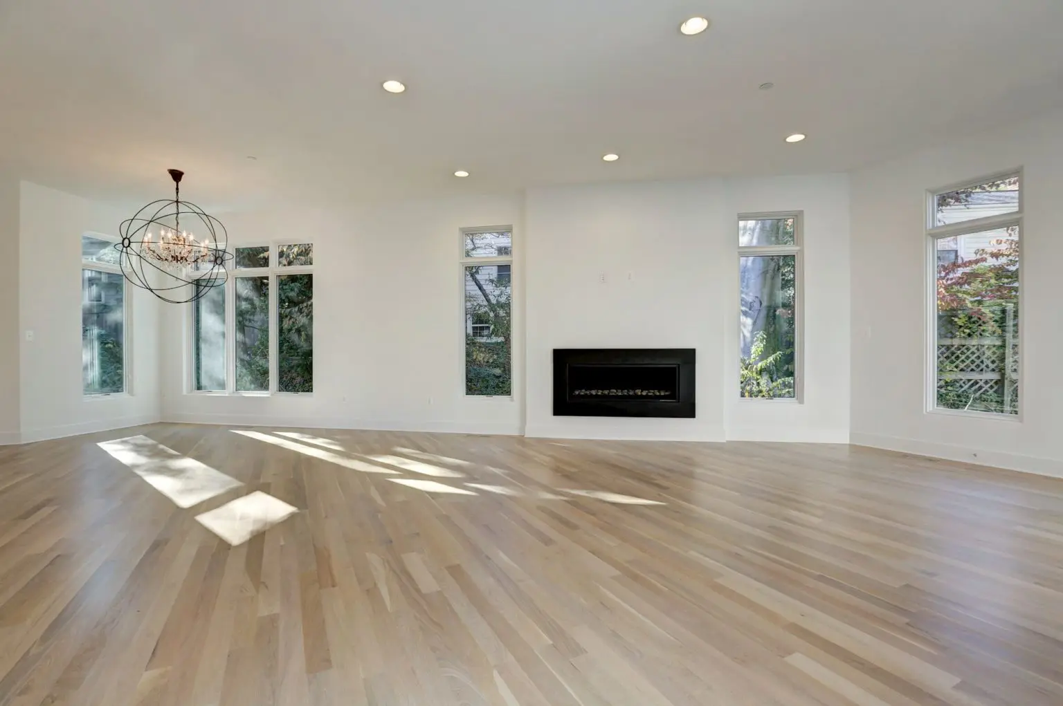 Three windows frame the trees; the fire answers back