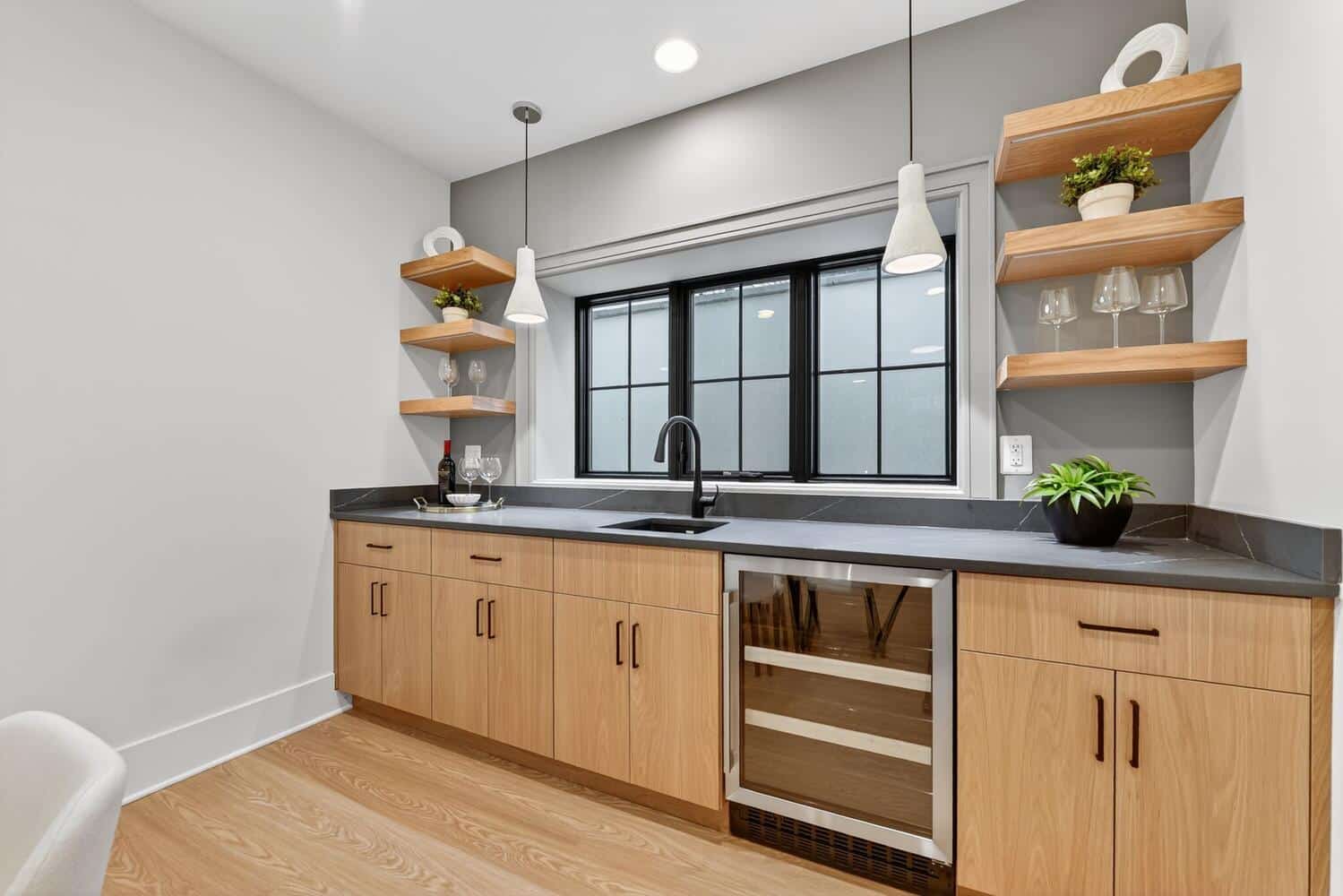 Floating shelves, wine fridge. The lower level pours its own drinks.