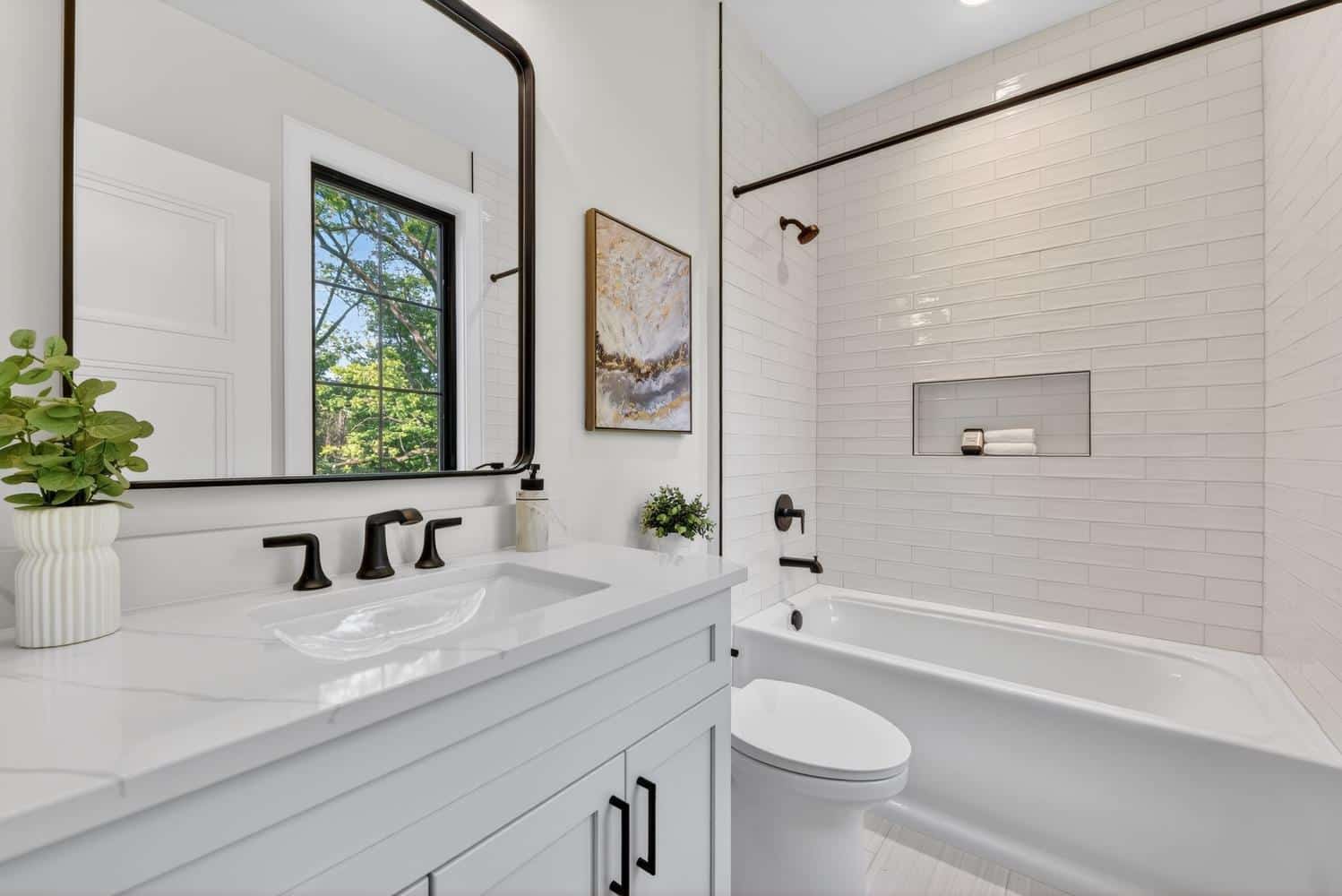 Subway tile, matte black fixtures, and quartz — a clean, timeless bath.