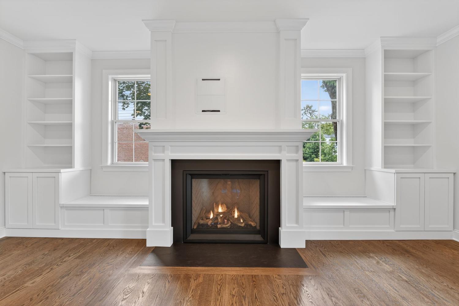 Fireplace flanked by built-ins, windows on both sides