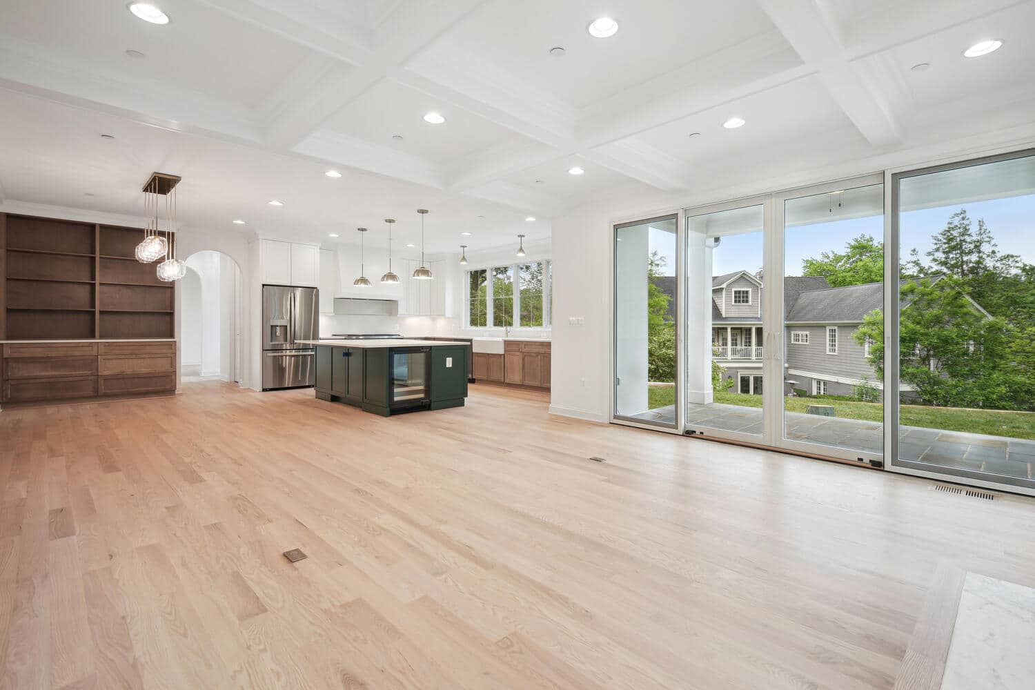 Island anchors the open plan, glass wall extends it